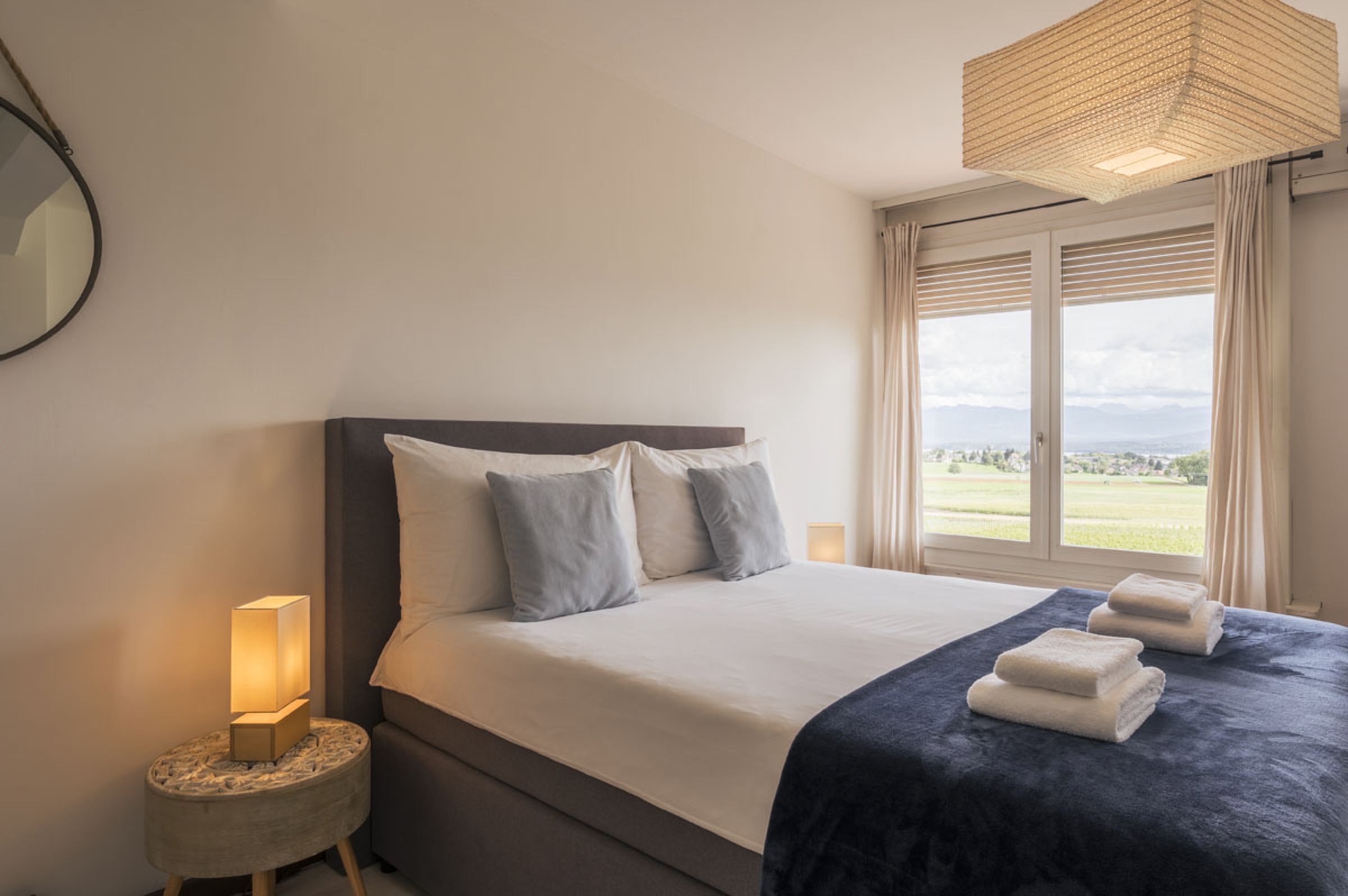 Premium serviced apartment bedroom with Swiss vineyard and mountain views
